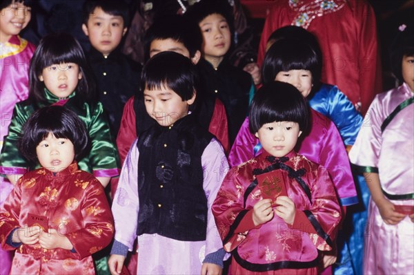 Children celebrating the Chinese New Year. Young children wear traditional Chinese dress during celebrations for the Chinese New Year. London, England, circa 1985. London, London, City of, England (United Kingdom), Western Europe, Europe .