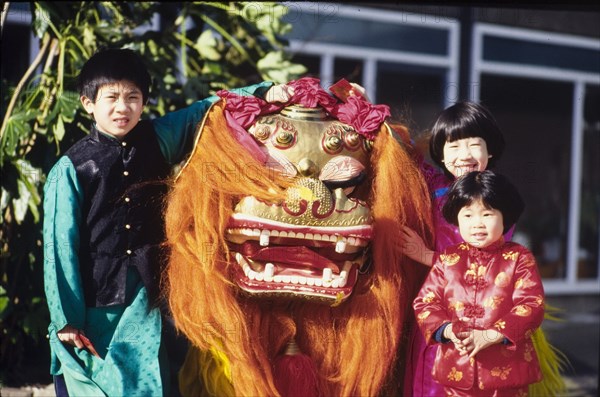 Children with a Chinese dragon. Three children pose with a traditional Chinese dragon during celebrations for Chinese New Year. London, England, circa 1985. London, London, City of, England (United Kingdom), Western Europe, Europe .