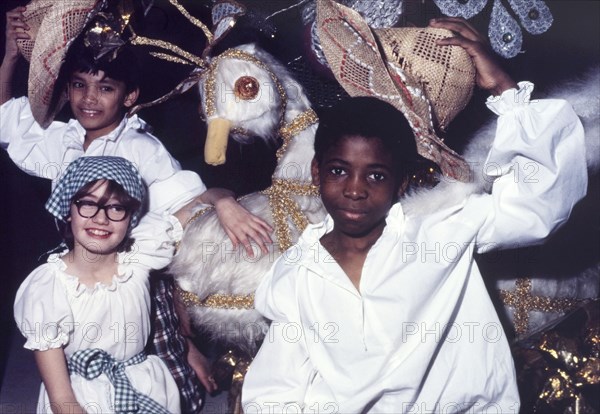 Children at a Commonwealth Institute festival. Children in costume pose beside a large-scale model of a white bird during a cultural festival held at the Commonwealth Institute. London, England, circa 1985. London, London, City of, England (United Kingdom), Western Europe, Europe .