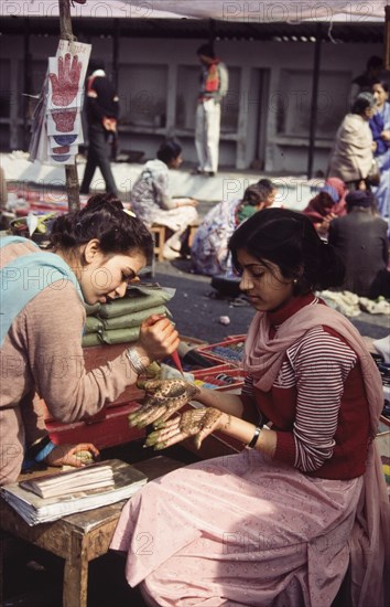 Applying henna for Diwali celebrations. A young woman has the palm of her hands decorated with henna paste ('mehndi' ) during celebrations for Diwali, the Hindu festival of light. London, England, circa 1985. London, London, City of, England (United Kingdom), Western Europe, Europe .