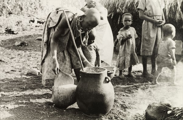 Kikuyu woman crafting pottery. A Kikuyu woman makes a clay pot outdoors at a "family pottery", a traditional female skill according to an original caption. South Nyeri, Kenya, 1936. Nyeri, Central (Kenya), Kenya, Eastern Africa, Africa.