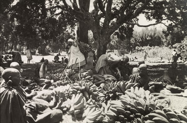 Plantain stall at Karatina market . Kikuyu traders display large bunches of plaintains on a stall at Karatina market. South Nyeri, Kenya, 1936. Nyeri, Central (Kenya), Kenya, Eastern Africa, Africa.