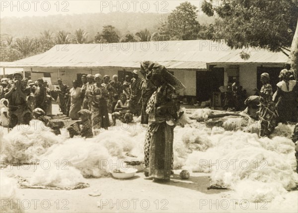 Fishing nets at a Ghanaian market. A street trader sells fishing nets at a marketplace near the Volta River. Volta Region, Gold Coast (Ghana), circa 1950., Volta, Ghana, Western Africa, Africa.