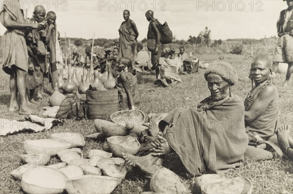 Calabashes on sale at a Kikuyu market. Customers peruse a selection of gourds and calabashes for sale at a Kikuyu market. Nyeri, Kenya, circa 1935. Nyeri, Central (Kenya), Kenya, Eastern Africa, Africa.