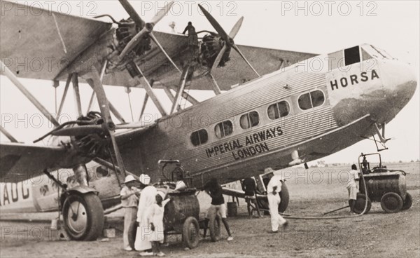 Refueling an Imperial Airways biplane, Kenya. Ground crew refuel an Imperial Airways long-range biplane, the G-AAUC Horsa, at a Kenyan airfield. Kenya, 1933. Kenya, Eastern Africa, Africa.
