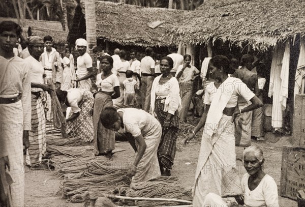 Rope sellers in Ceylon. Women sell bundles of rope at an outdoor market. Ceylon (Sri Lanka), 1936. Sri Lanka, Southern Asia, Asia.
