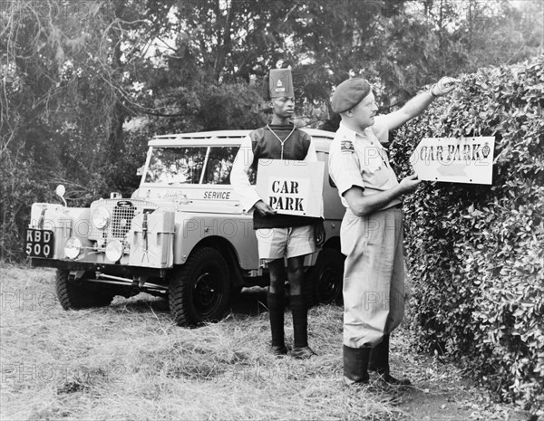 Kenyan Road Service preparing for royal visit. Two employees of the Kenyan Road Service erect car parking signs in preparation for a royal visit by Princess Elizabeth and the Duke of Edinburgh. Nairobi, Kenya, February 1952. Nairobi, Nairobi Area, Kenya, Eastern Africa, Africa.