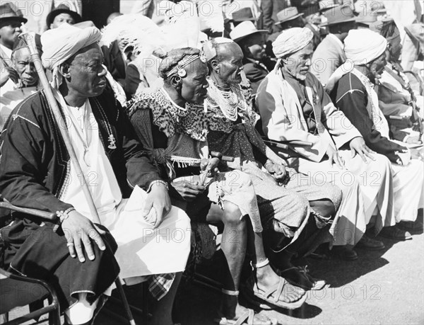 Awaiting the arrival of Princess Elizabeth. An assembly of African chiefs in ceremonial dress sit on a spectator stand as they await the arrival of Princess Elizabeth at Eastleigh Airport. Nairobi, Kenya, February 1952. Nairobi, Nairobi Area, Kenya, Eastern Africa, Africa.