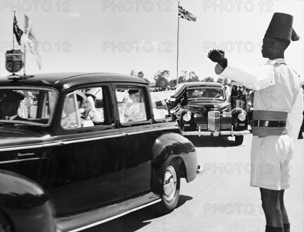The royal couple leave Eastleigh Airport. Princess Elizabeth and the Duke of Edinburgh wave goodbye to the crowds as they depart Eastleigh Airport in an open car, shortly after arriving in Kenya for an official royal visit. Nairobi, Kenya, February 1952. Nairobi, Nairobi Area, Kenya, Eastern Africa, Africa.
