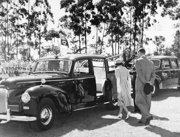 The royal couple leave Government House. Princess Elizabeth and the Duke of Edinburgh prepare to climb into a chauffeur driven car as they leave Government House following an official reception to start their royal tour of Kenya. Nairobi, Kenya, February 1952. Nairobi, Nairobi Area, Kenya, Eastern Africa, Africa.