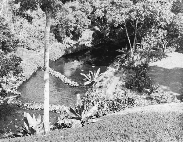 River in the gardens of the Royal Lodge. The Sagana River runs through the gardens of the Royal Lodge in Nyeri. The lodge was presented to Princess Elizabeth and the Duke of Edinburgh by the people of Kenya in 1952, but was not immediately visited by the royal couple, whose official tour of Kenya was cut unexpectedly short by the death of King George VI on 6 February. Nyeri, Kenya, February 1952. Nyeri, Central (Kenya), Kenya, Eastern Africa, Africa.