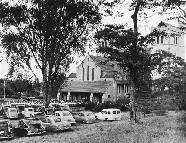 Memorial service for King George VI, Nairobi. A congregation of mourners sit on chairs outside All Saints Cathedral during a memorial service for King George VI, who died in his sleep at Sandringham House, England, on 6 February 1952. Nairobi, Kenya, circa 6 February 1952. Nairobi, Nairobi Area, Kenya, Eastern Africa, Africa.