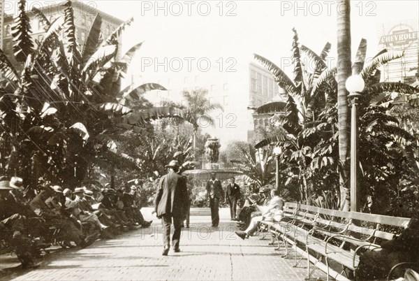 Pershing Square, Los Angeles. View along a tree-lined avenue leading to a decorative water fountain in Pershing Square, where visitors sit and relax on park benches. Los Angeles, United States of America, circa 1931. Los Angeles, California, United States of America, North America, North America .