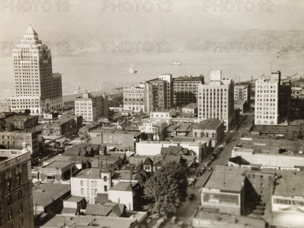 Vancouver, Canada. View over the rooftops of Vancouver to False Creek, where the British Royal Navy's HMS Dauntless is anchored. Vancouver, Canada, circa 1931. Vancouver, British Columbia, Canada, North America, North America .