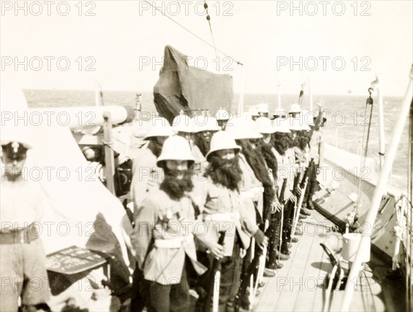 King Neptune's bodyguard. Crew members aboard the HMS Dauntless line up on deck dressed in fake beards and helmets, disguised as King Neptune's bodyguards for a 'crossing the line' ceremony. South Atlantic Ocean near the coast of Brazil, circa 1931., South Atlantic Ocean, South America .