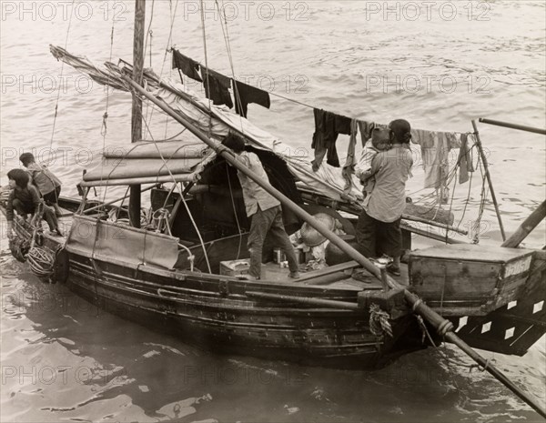 A Chinese family afloat. A Chinese family with three young children travel aboard a domestic sampan. An original caption comments that the "people in these craft(s) have no other home. In them they are born, live, marry and die. As fish are always plentiful no one goes hungry and there is no abject poverty here". Aberdeen, Hong Kong, China, 1963. Hong Kong, Hong Kong, China, People's Republic of, Eastern Asia, Asia.