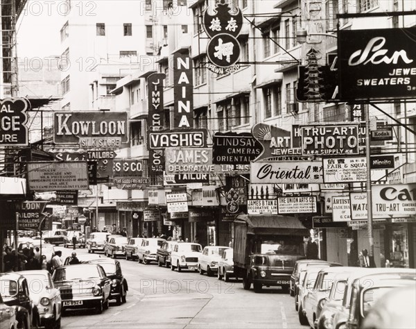 Cameron Road, Kowloon. English shop signs and advertisements vie for attention on Cameron Road in the heart of the tourist shopping district. Kowloon, Hong Kong, China, 1963. Kowloon, Hong Kong, China, People's Republic of, Eastern Asia, Asia.
