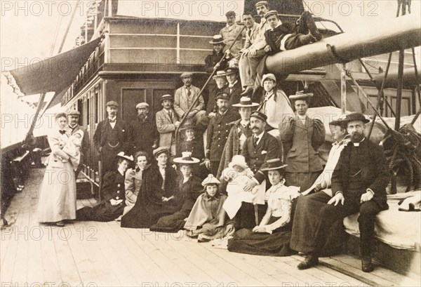 Passengers and crew of S.S. Edinburgh. The Captain of S.S. Edinburgh holds baby Jess Murray on his lap, as he poses on deck for a group portrait with first class passengers and ship officers. The S.S. Edinburgh was travelling from England to Calcutta (Kolkata). Indian Ocean, 1898., Indian Ocean, Africa.