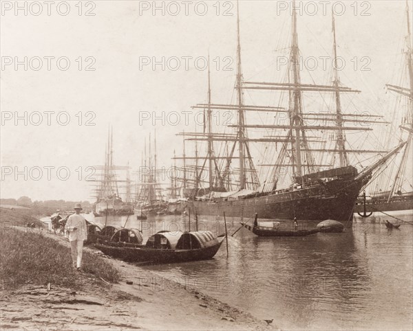 Vessels moored on the Hooghly River. Small boats beached on the sandy banks of the Hooghly River are dwarfed by the large European sailing ships moored near Calcutta port. Calcutta (Kolkata), India, circa 1887. Kolkata, West Bengal, India, Southern Asia, Asia.