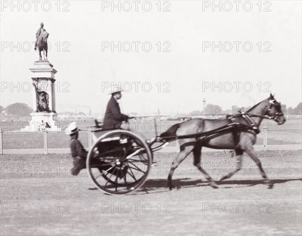 Driving a tonga, India. James Murray drives a horse-drawn tonga along a track in Calcutta. Calcutta (Kolkata), India, circa 1900. Kolkata, West Bengal, India, Southern Asia, Asia.