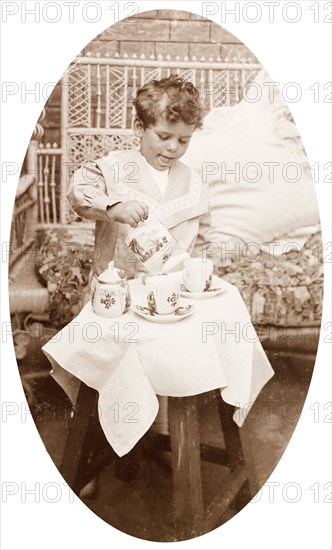 James Murray playing with a tea set. Four year old James Murray playing with a tea set during a trip to India to visit his father. Calcutta (Kolkata), India, 1910. Kolkata, West Bengal, India, Southern Asia, Asia.