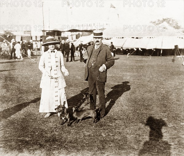 British couple at a dog show, Calcutta. James and Minnie Murray pose with their prize-winning dachshunds, Hunden and Piper, at a dog show in Calcutta. Calcutta (Kolkata), India, 1912. Kolkata, West Bengal, India, Southern Asia, Asia.