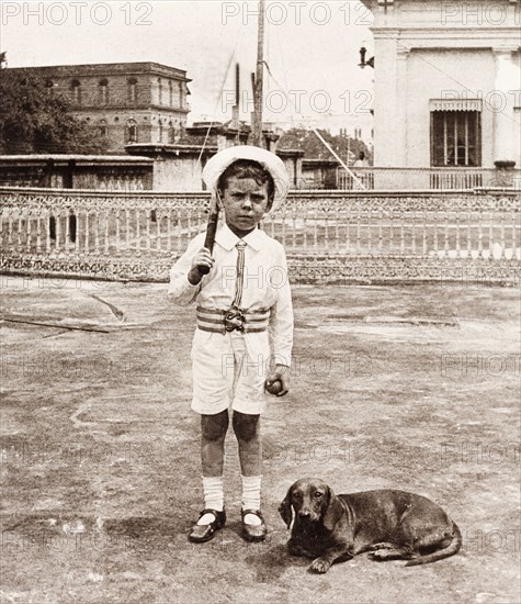 Playing cricket on a rooftop garden, Calcutta. Six year old James Murray, accompanied by his pet dog, plays cricket on a rooftop garden in Calcutta, during a trip to India to visit his father. Calcutta (Kolkata), India, 1912. Kolkata, West Bengal, India, Southern Asia, Asia.