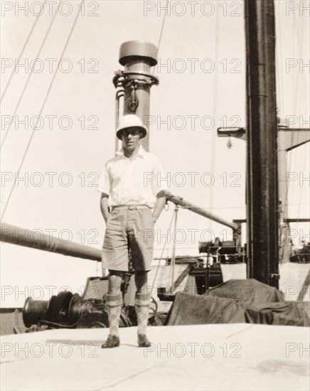 James Murray on deck of S.S. Domala. James Murray stands on the deck of the passenger liner S.S. Domala, posing in his brand new solatopi, as he travels from London to Calcutta (Kolkata) to take over the family business. Indian Ocean, October 1930., Indian Ocean, Africa.