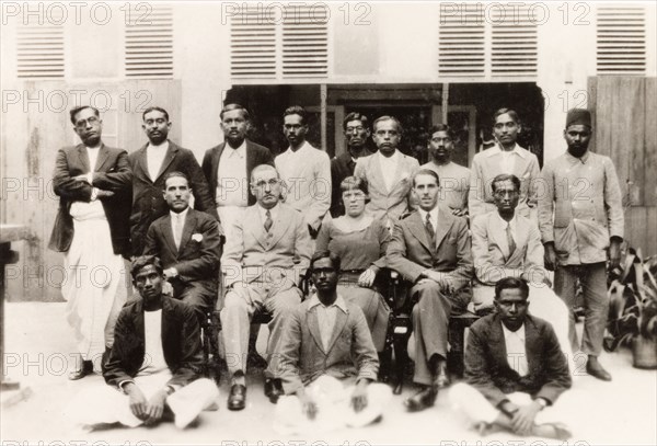Office staff of 'James Murray and Company'. The office staff of 'James Murray and Company' pose for a group portrait. The owner, James Murray, sits in the middle row (second to right) next to the store manager and his wife. Calcutta (Kolkata), India, 1932. Kolkata, West Bengal, India, Southern Asia, Asia.