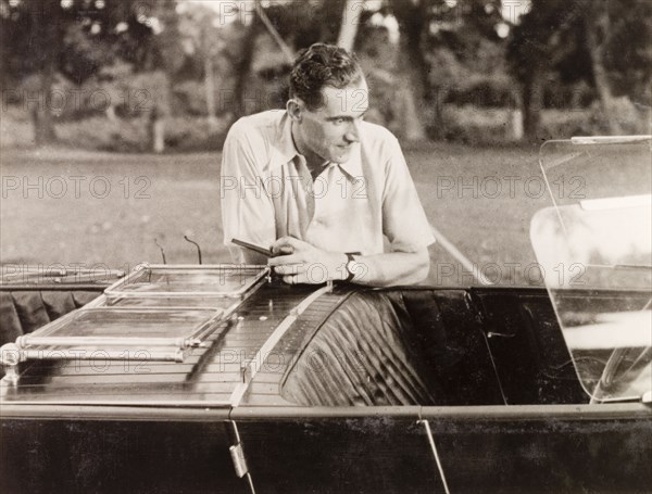 Posing by an Avion Voisin car. British colonist Noel Stokes poses by his Avion Voisin car as he prepares to embark on a journey along the Grand Trunk Road from Calcutta to Ranchi. Calcutta (Kolkata), India, June 1932. Kolkata, West Bengal, India, Southern Asia, Asia.