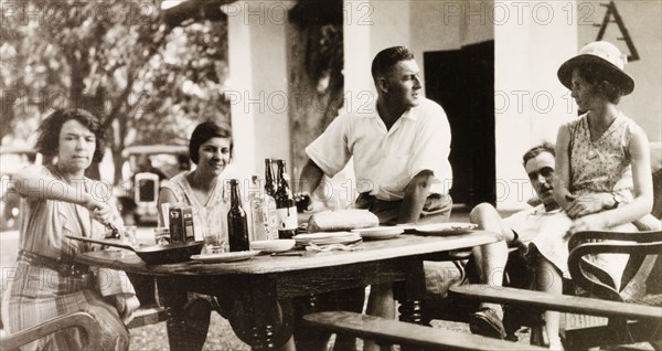Dining at a dak bungalow, Hazaribagh. A group of friends sit and eat a meal outside a dak bungalow (traveller's rest house) in Hazaribagh, during their road trip on the Grand Trunk Road from Calcutta (Kolkata) to Ranchi. Hazaribagh, Bihar (Jharkhand), India, June 1932. Hazaribagh, Jharkhand, India, Southern Asia, Asia.
