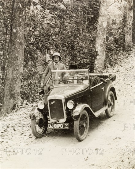 Dr Tweedie posing by his Austin 7. Dr Reid Tweedie poses by his Austin 7 car on a rural road in the Dooars, a flood plain region in the foothills of the eastern Himalayas. Assam, India, April 1935., Assam, India, Southern Asia, Asia.