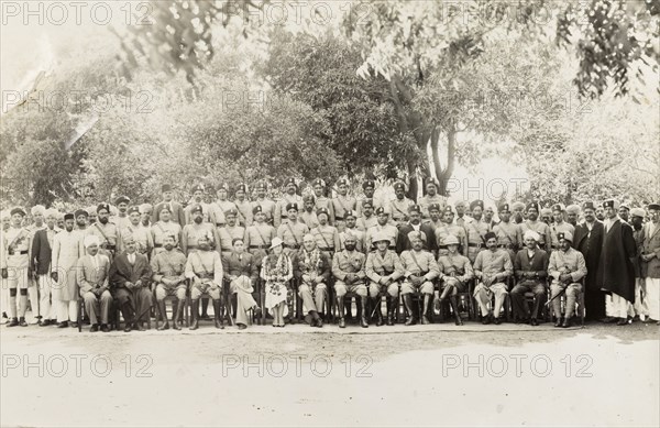 Indian police force. Group portrait of a line up of Indian and British police officers. The Chief of Police, Sir Philip Measures, and his wife Muriel sit in the front centre, adorned with garlands of flowers. India, circa 1925. India, Southern Asia, Asia.