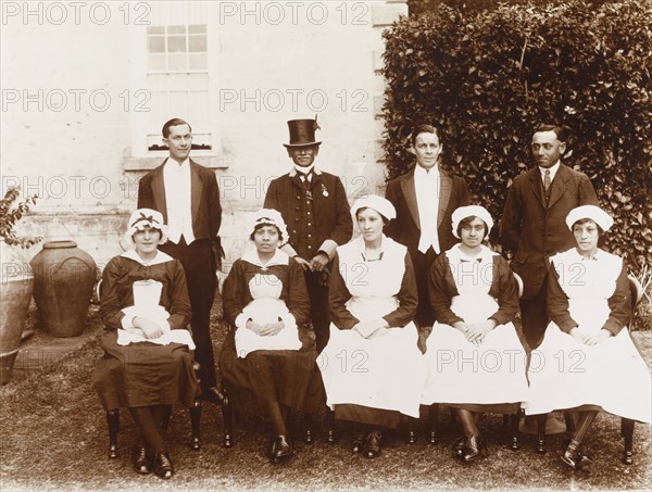 Household staff, St Helena. Outdoors portrait of the uniformed household staff of a colonial residence. St Helena, circa 1910. St Helena, Atlantic Ocean, Africa.