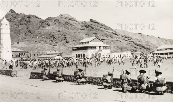 Policing the Aden riots, 1947. Armed police or soldiers form a defensive barrier behind a low wall, separating them from a crowd during Arab riots that took place in response to the United Nations Partition Plan for Palestine. Aden, Yemen, 1-3 December 1947. Aden, Adan, Yemen, Middle East, Asia.