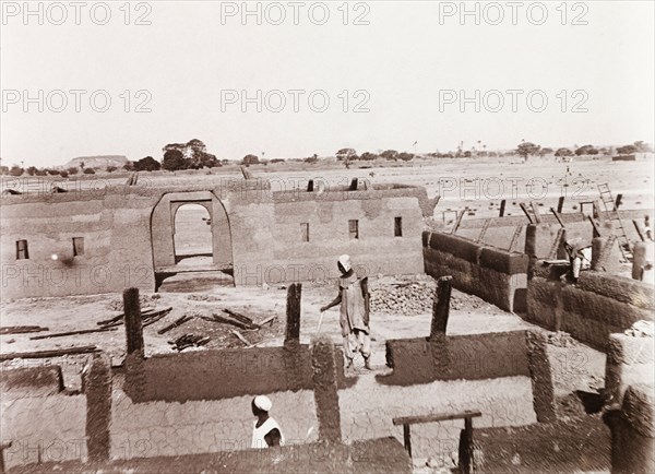 Construction of a new school in Kano. View over the construction site of a new school, where Nigerian builders work amidst a maze of partially completed mud walls. Kano, Nigeria, 1914. Kano, Kano, Nigeria, Western Africa, Africa.