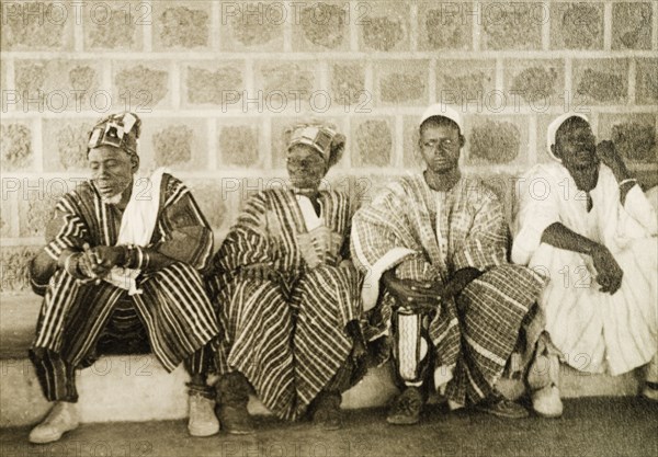 Ghanaian chiefs at a conclave. Four Ghanaian chiefs attend a conclave in traditional dress. Northern Territories, Gold Coast (Ghana), circa 1950. Ghana, Western Africa, Africa.
