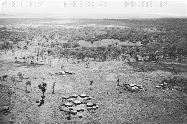 A Luo settlement on the Kano plains. Clusters of huts comprise a Luo settlement on the Kano plains, close to Lake Victoria. Nyanza, Kenya, circa 1935., Nyanza, Kenya, Eastern Africa, Africa.