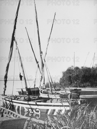 Dhows at Kisumu on Lake Victoria'. Painted dhows are moored near the port city of Kisumu on the banks of Lake Victoria. Kisumu, Kenya, circa 1935. Kisumu, Nyanza, Kenya, Eastern Africa, Africa.