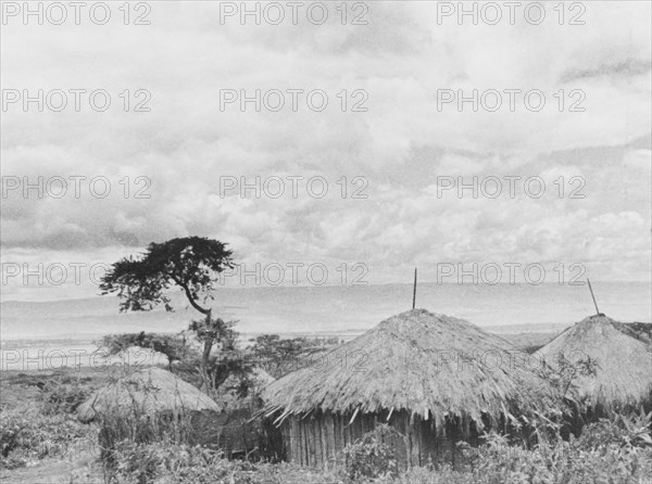 Kikuyu settlement below the Aberdare Mountains. Thatched huts belonging to a Kikuyu settlement sit in a valley below the Aberdare Mountains. Rift Valley, Kenya, circa 1935., Rift Valley, Kenya, Eastern Africa, Africa.