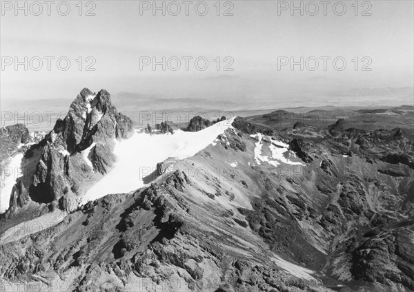 Batian Peak at Mount Kenya, 1936. An aerial view of Batian Peak, the highest peak of Mount Kenya at 5,199 metres, with snow below the summit. Mount Kenya, Central Kenya, 1936., Central (Kenya), Kenya, Eastern Africa, Africa.