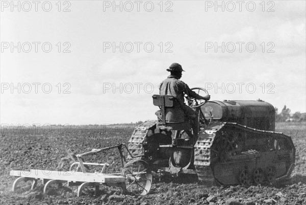 Ploughing in the Uasin Gishu plateau. An African farm hand uses a tractor to plough a field in the Uasin Gishu plateau. Rift Valley, Kenya, circa 1950., Rift Valley, Kenya, Eastern Africa, Africa.