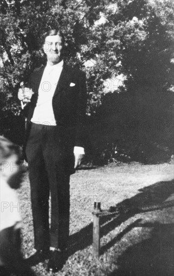 Portrait of Raymond Hook. Full-length portrait of Raymond Hook, an eccentric settler farmer with a game ranch near Nanyuki. Hook is most often remembered for successfully cross-breeding zebras with domestic horses and for his attempts to bring cheetah racing to England. An original caption comments that he was found murdered in 1968. Nanyuki, Kenya, circa 1940. Nanyuki, Central (Kenya), Kenya, Eastern Africa, Africa.