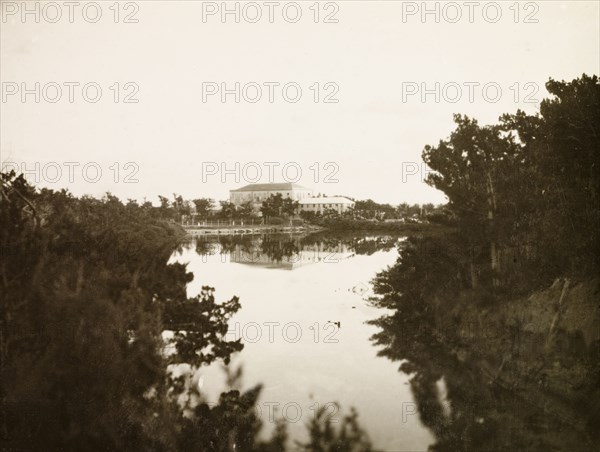Canteen Lagoon', Bermuda. View across the still waters of an inland bay looking towards a large colonial building in the distance. An original caption identifies this as 'Canteen Lagoon'. Bermuda, circa 1931., Bermuda, Bermuda, Atlantic Ocean, Africa.