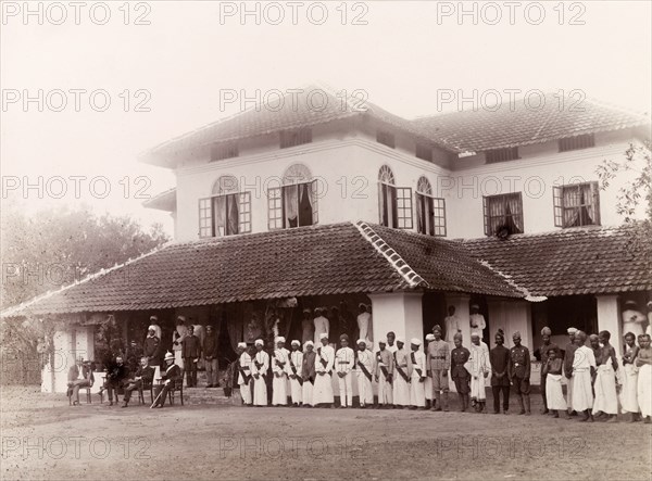 Awaiting the Governor of Madras's arrival. British officials and the Elaya Rajah (heir apparent) of Nilambur assemble on the lawn of Edakkara lodge, awaiting the arrival of Sir Arthur Lawley, the Governor of Madras. Uniformed household staff and servants also line up in front of the house ready to greet the Governor. Edakkara, Malabar District (Kerala), India, March 1908., Kerala, India, Southern Asia, Asia.