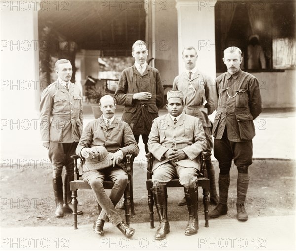 Group portrait of Governor of Madras and Elaya Rajah of Nilambur . Group portrait of Sir Arthur Lawley, Governor of Madras, and the Elaya Rajah (heir apparent) of Nilambur (both seated), posing with British officials by the veranda of Edakkara lodge. Sir Arthur Lawley visited Edakkara to attend a hunting expedition in the Nilgiri Hills with the Elaya Rajah. Edakkara, Malabar District (Kerala), India, March 1908., Kerala, India, Southern Asia, Asia.