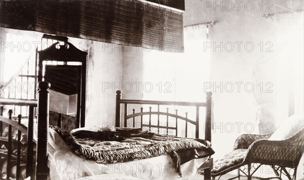 Governor' s bedroom at Edakkara lodge. Interior shot of a bedroom in the bungalow at Edakkara hunting lodge, taken during the stay of Sir Arthur Lawley, Governor of Madras. Above the bed hangs a 'pukka', a length of material swished by a servant to keep the occupant cool at night. Edakkara, Malabar District (Kerala), India, March 1908., Kerala, India, Southern Asia, Asia.