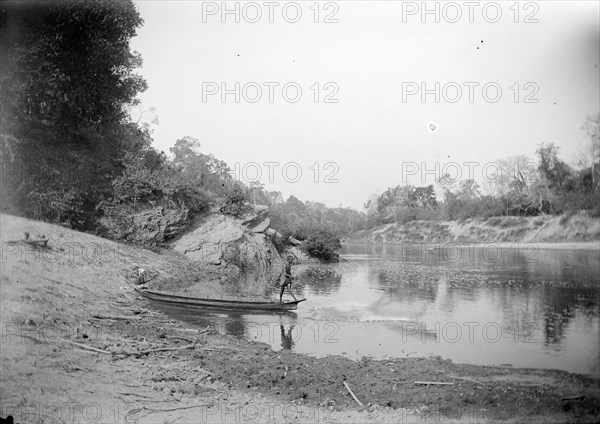 Burmese fisherman. A fisherman casts his net into the shallows of a river from the bow of his canoe. Burma (Myanmar), circa 1890. Burma (Myanmar), South East Asia, Asia.