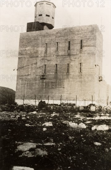 Fortified police building, Palestine. View of a large, fortified building with a projecting octagonal watchtower, surrounded by a barbed wire fence. This building was possibly used by British police forces as a gaol or police headquarters. British Mandate of Palestine (Middle East), circa 1942., Middle East, Asia.