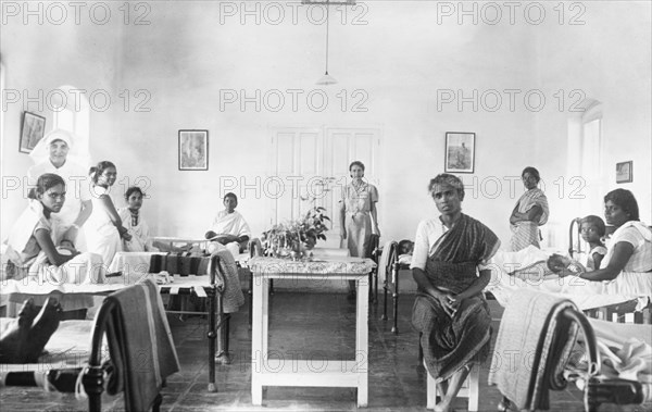 Maternity ward of a mission hospital, India. Two British nurses tend to Indian mothers and their babies on the maternity ward of a hospital run by the London Missionary Society. India, circa 1930. India, Southern Asia, Asia.